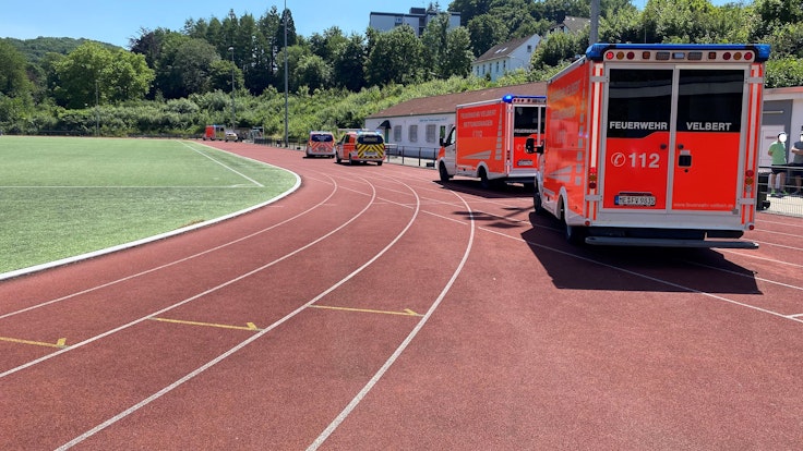 Feuerwehrwagen stehen an einem Sportplatz.