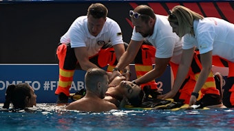 Anita Alvarez wird nach ihrer Rettung im Wasser bei der Schwimm-WM in Budapest von Sanitäterinnen und Sanitätern am Beckenrand in Empfang genommen.