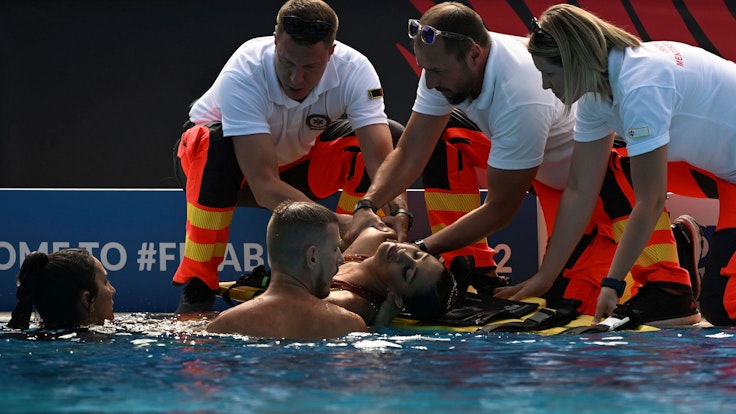 Anita Alvarez wird nach ihrer Rettung im Wasser bei der Schwimm-WM in Budapest von Sanitäterinnen und Sanitätern am Beckenrand in Empfang genommen.