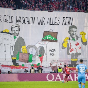 Mit einem Transparent „Für Geld waschen wir alles rein“ protestieren Münchner Fans in der Allianz Arena.