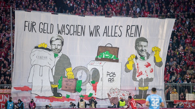 Mit einem Transparent „Für Geld waschen wir alles rein“ protestieren Münchner Fans in der Allianz Arena.