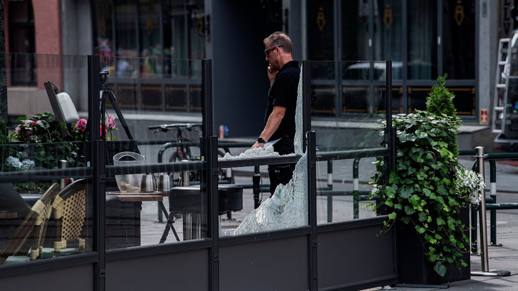 Die Polizei untersucht das Restaurant, dessen Fenster am 25. Juni 2022 in Oslo durch eine Schießerei zerstört wurden.