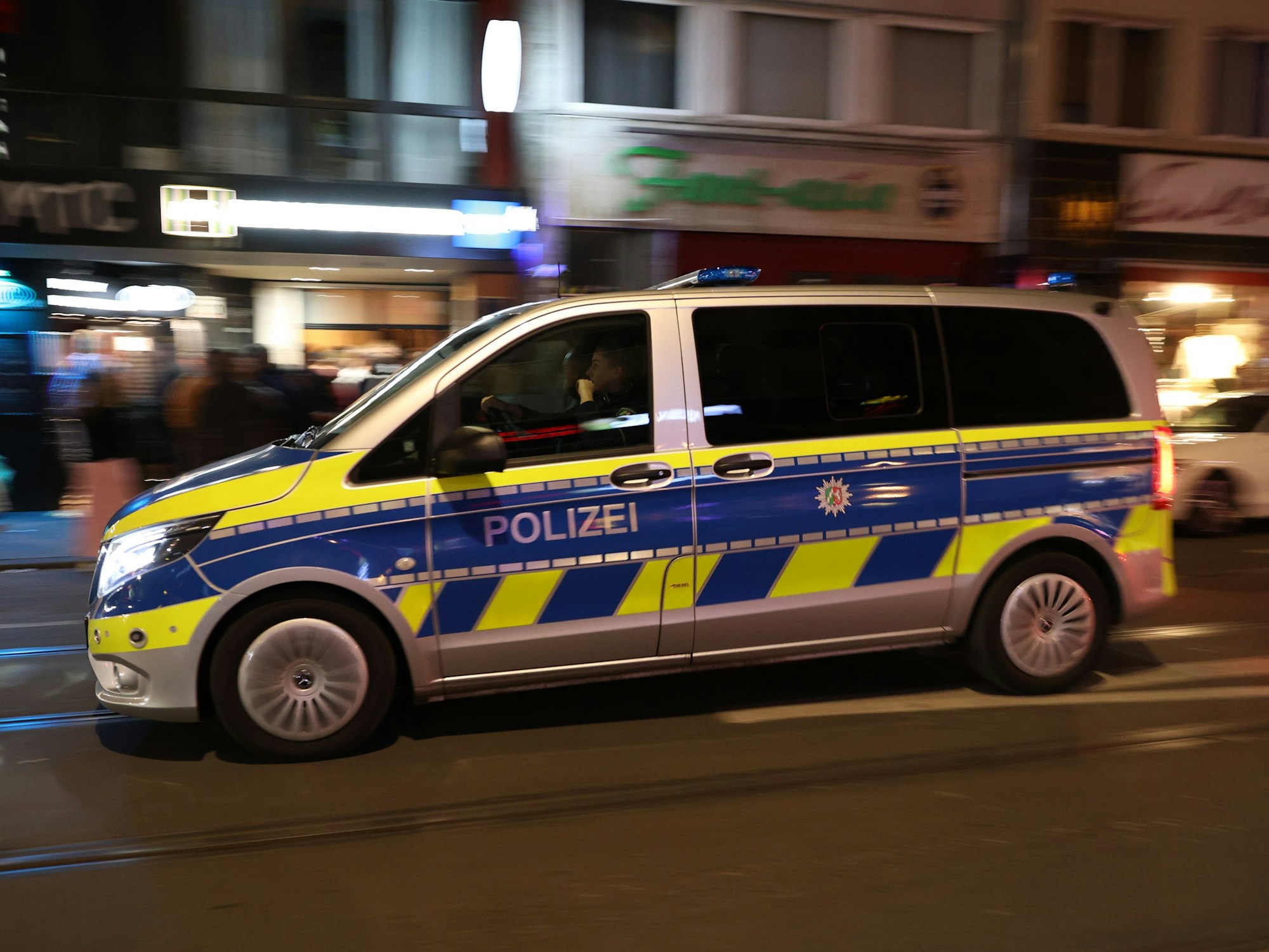 Ein Polizeiwagen fährt am Abend über die Zülpicher Straße.