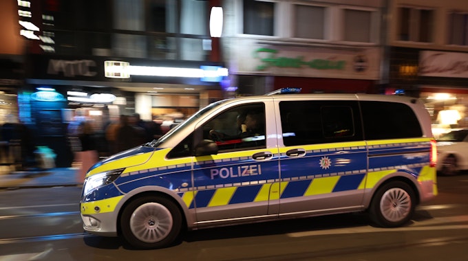 Ein Polizeiwagen fährt am Abend über die Zülpicher Straße.