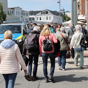 Auf Sylt kommt es seit Einführung des 9-Euro-Tickets zu teils chaotischen Szenen. Unser Foto zeigt Reisende und ein Polizeifahrzeug am 3. Juni 2022 in Westerland.
