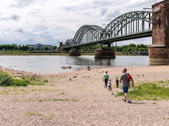 Spaziergänger gehen zum Rheinufer an der Südbrücke.