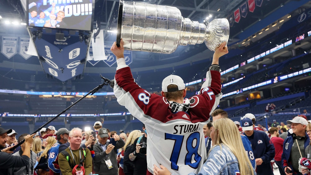Nico Sturm hält die Trophäe für den Gewinn des Stanley Cups in die Höhe.