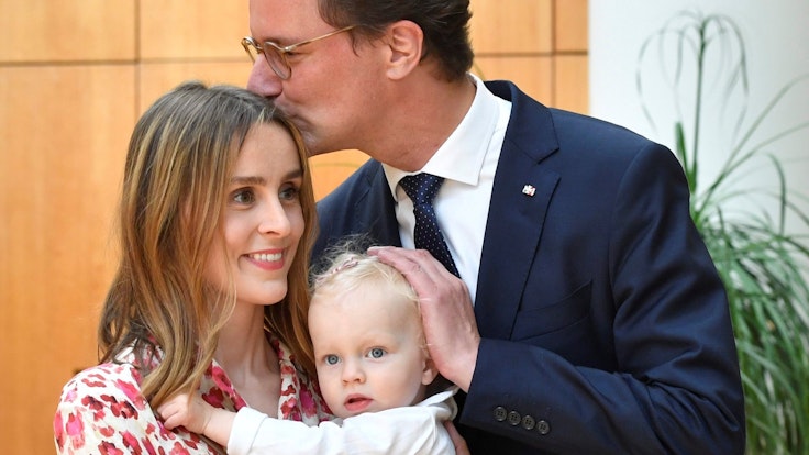 Hendrik Wüst küsst seine Ehefrau Katharina und Tochter Philippa im Landtag.