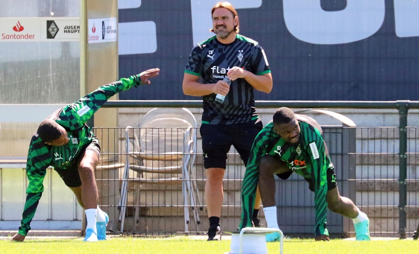 Gladbach-Trainer Daniel Farke schaut beim Training (28. Juni 2022) der Profis im Borussia-Park genau hin. Im Vordergrund sind Alassane Plea (l.) und Marcus Thuram (r.) zu sehen.