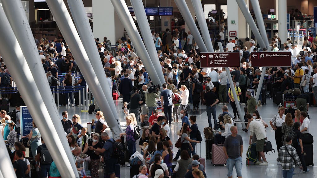 Passagiere stehen am 25. Juni 2022 im Flughafen Düsseldorf und warten auf ihre Abfertigungen. 