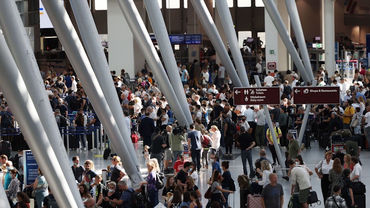 Passagiere stehen am 25. Juni 2022 im Flughafen Düsseldorf und warten auf ihre Abfertigungen.