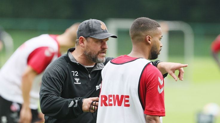 Steffen Baumgart gibt Neuzugang Linton Maina beim 1. FC Köln Anweisungen im Training