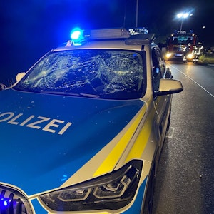 Ein Streifenwagen der Polizei steht mit einer von einem Angreifer zerstörten Windschutzscheibe am Straßenrand in Amberg
