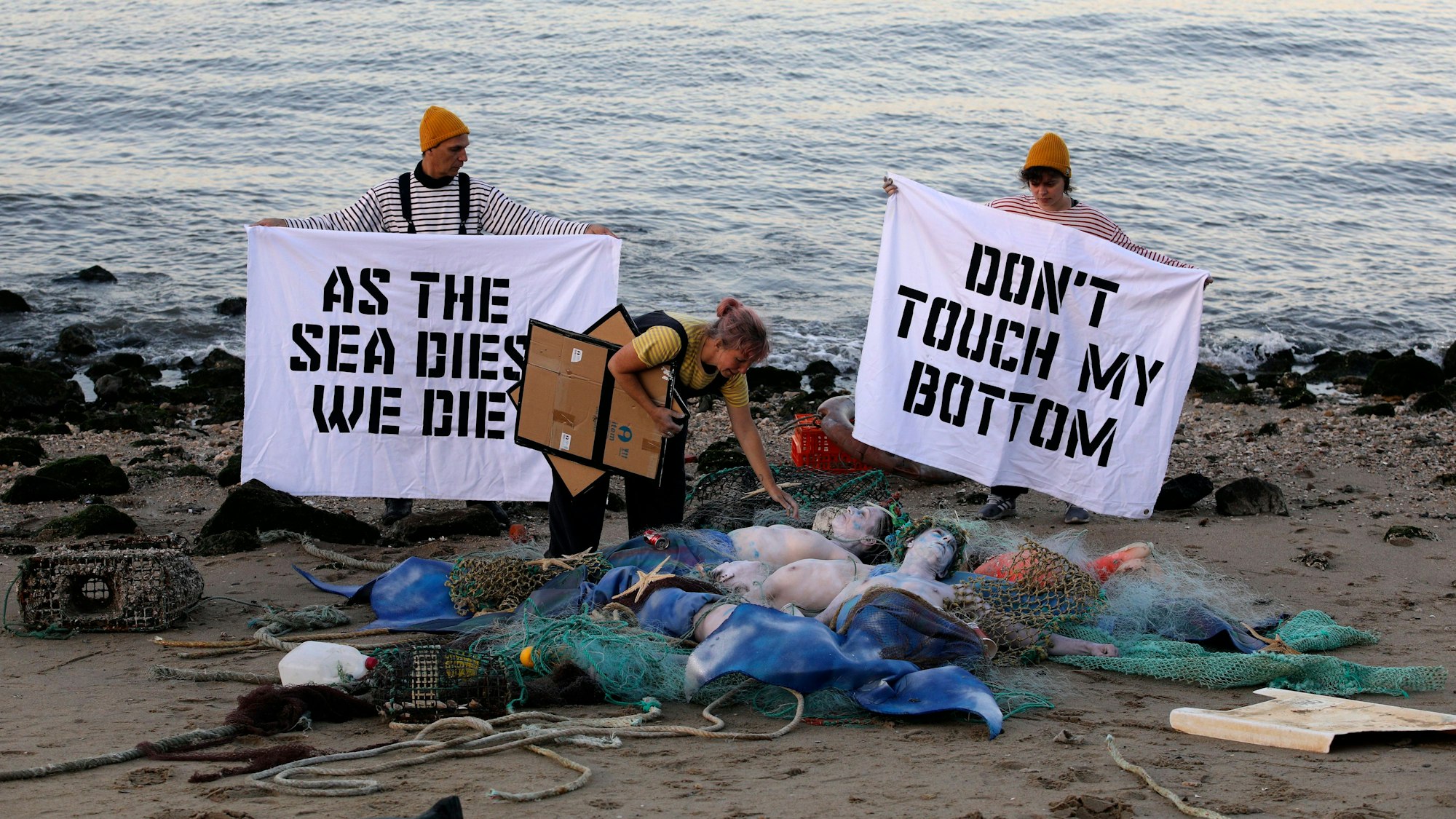 Aktivisten der Ocean Rebellion veranstalten am Ufer des Tejo eine Performance, bei der sie ein Ende aller nationalen Treibstoffsubventionen für Fischereiflotten und ein Verbot der Grundschleppnetzfischerei fordern.