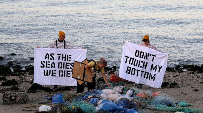 Aktivisten der Ocean Rebellion veranstalten am Ufer des Tejo eine Performance, bei der sie ein Ende aller nationalen Treibstoffsubventionen für Fischereiflotten und ein Verbot der Grundschleppnetzfischerei fordern.