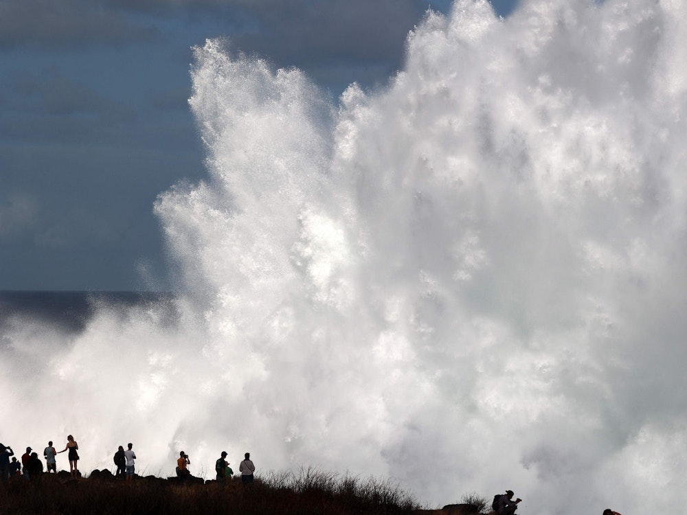 Einwohner und Einwohnerinnen beobachten eine riesige Welle in Saint-Leu, im Süden der französischen Insel Réunion.