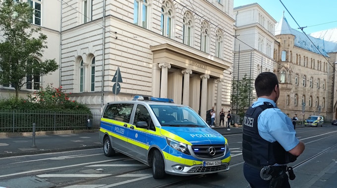 Polizei-Auto und Polizist vor dem Landgericht in Bonn.