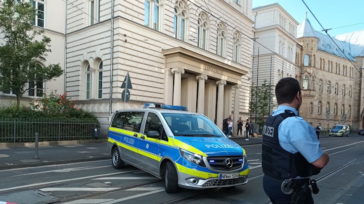 Polizei-Auto und Polizist vor dem Landgericht in Bonn.