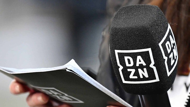 Ein Mikrofon und Moderations-Karten mit dem Logo des Streaming-Anbieters DAZN
