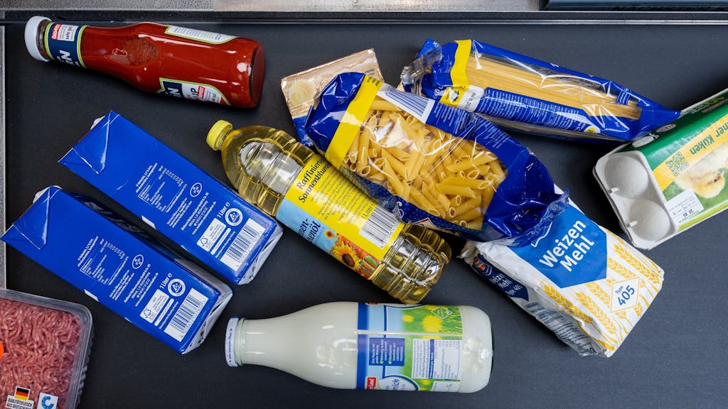 Lebensmittel, darunter Sonnenblumenöl und Getreideprodukte, liegen in einem Supermarkt in Leipzig an der Kasse auf dem Band. Der Einzelhandel plant weitere Preiserhöhungen, Bauernpräsident Joachim Rukwied sorgt sich vor allem um die Folgen bei einem Gasmangel.