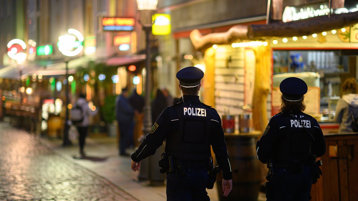 Deutschland in Zeiten des Corona-Lockdowns: Polizisten gehen am Abend in der Dresdner Altstadt an Restaurants entlang.