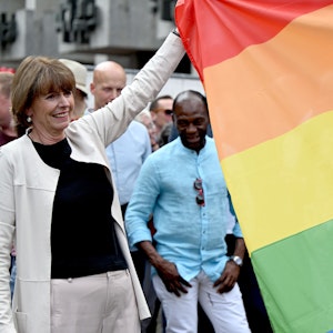 Henriette Reker, Kölner Oberbürgermeisterin, hilft beim Hissen einer Regenbogen-Flagge.