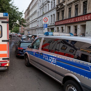 Ein Rettungswagen und ein Polizeifahrzeug stehen auf einer Straße bei einem Einsatz am 15. Juli 2021 in Leipzig.