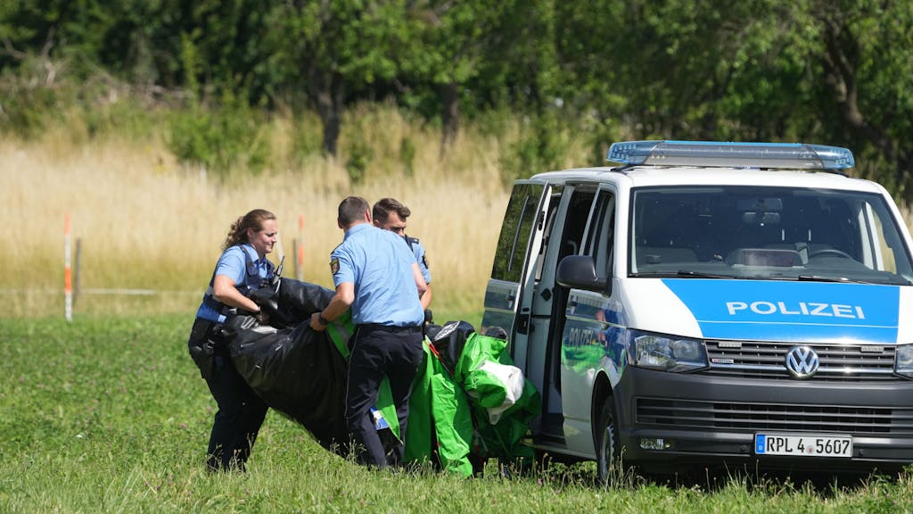 Rheinland-Pfalz, Gondershausen: Polizeibeamte transportieren die Hülle einer Hüpfburg ab.