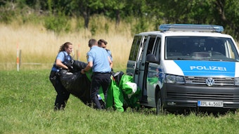 Rheinland-Pfalz, Gondershausen: Polizeibeamte transportieren die Hülle einer Hüpfburg ab.