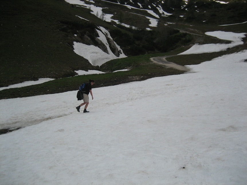 Eine Wanderin geht im Mai 2017 durch ein Schneefeld am Jenner in den Berchtesgadener Alpen in Bayern.