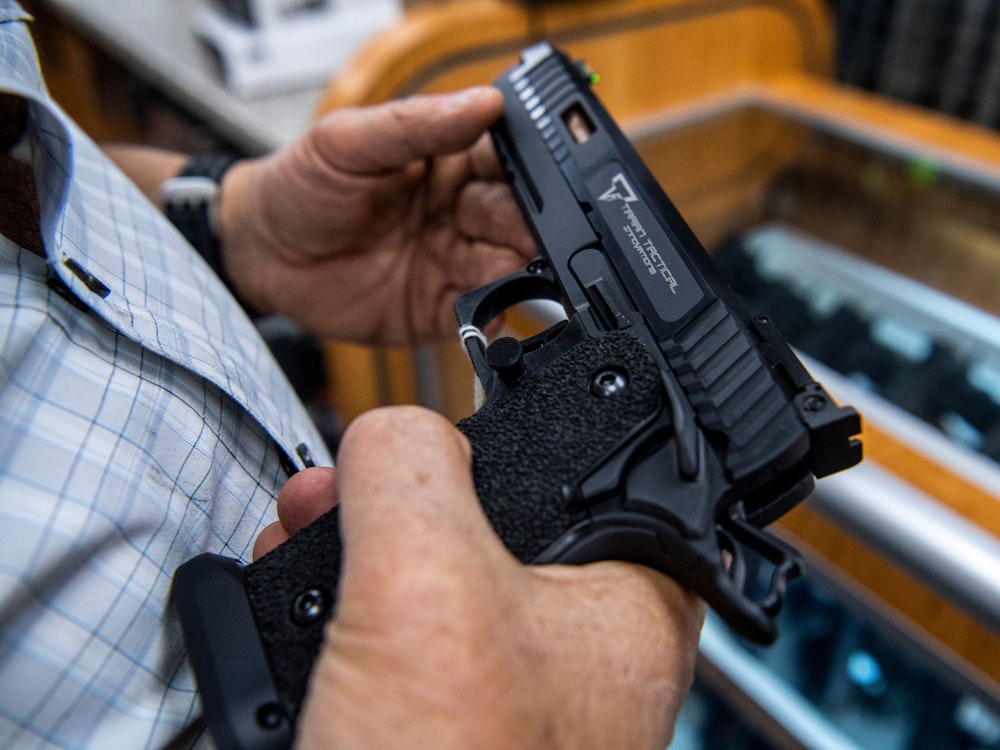 Ein Kunde prüft eine Handfeuerwaffe, die zum Verkauf steht und bei SP firearms ausgestellt ist.