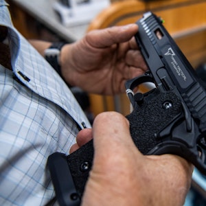 Ein Kunde prüft eine Handfeuerwaffe, die zum Verkauf steht und bei SP firearms ausgestellt ist.