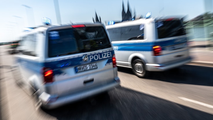 Polizeifahrzeuge sind mit Blaulicht auf der Deutzer Brücke in Köln unterwegs.