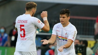 Jorge Meré (r.) und Rafael Czichos klatschen bei einer Auswechslung im Bundesliga-Spiel des 1. FC Köln gegen RB Leipzig ab