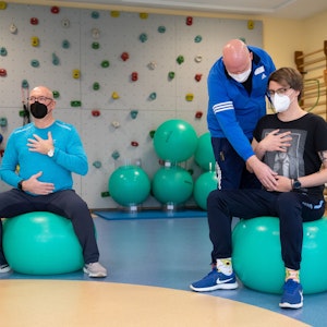 Die long-covid-Patienten Jörg Schneider (links) und Ulrich Lowers (rechts) machen ein Atemtraining mit Physiotherapeut Mirko Weernink in einem Gymnastikraum der Klinik Teutoburger Wald, eine Reha-Klinik für Post-Covid Erkrankte.