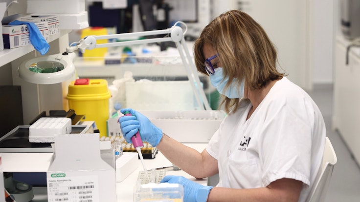 Eine Labortechnikerin arbeitet mit PCR-Tests in einem mikrobiologischen Labor