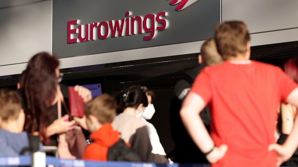 Passagiere stehen Schlange vor dem Check-in-Schalter von Eurowings im Flughafen Düsseldorf.