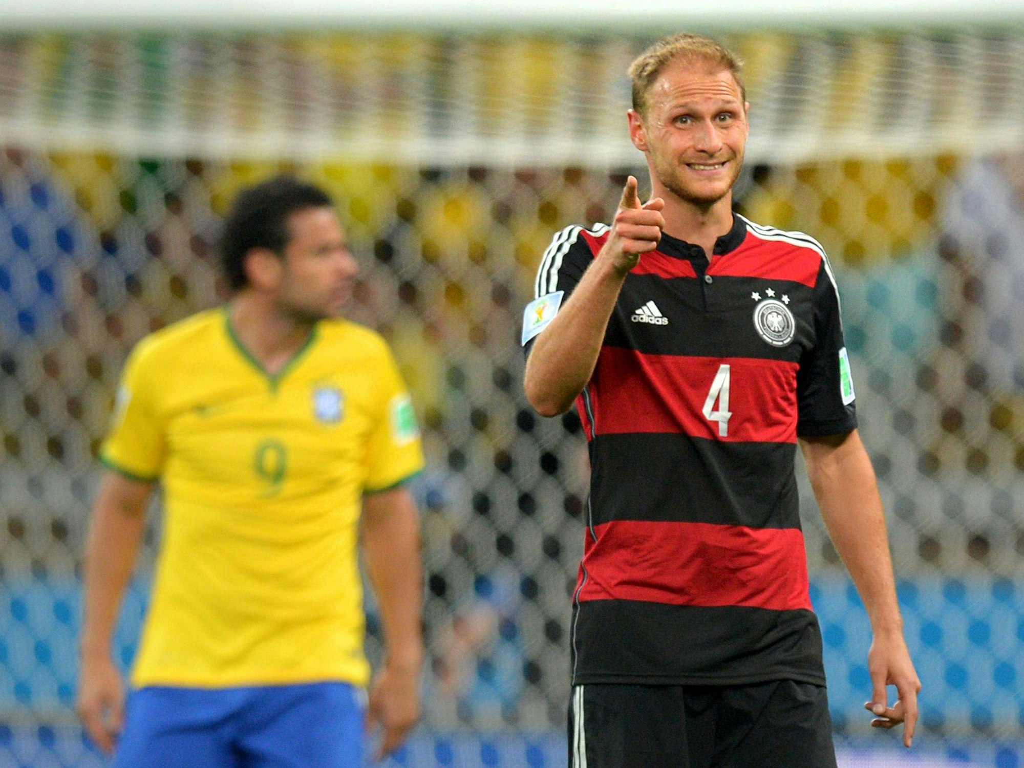 Benedikt Höwedes zeigt mit dem Zeigefinger nach vorne. Im Hintergrund ist Brasiliens Stürmer Fred zu sehen.