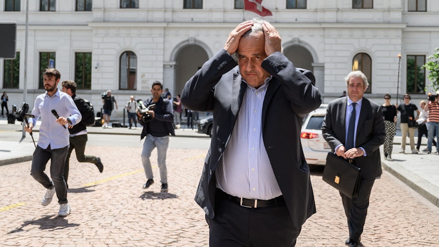 Michel Platini rauft sich vor einem Gerichtsgebäude in der Schweiz die Haare.