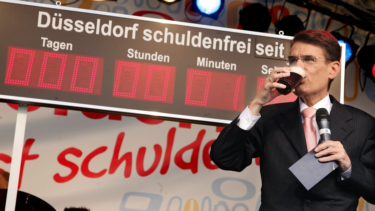 Der damalige Oberbürgermeister von Düsseldorf, Joachim Erwin (CDU), zeigt die Schuldenfrei-Uhr.