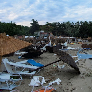 rümmer, umgekippte Sonnenschirme und Strandliegen liegen an einem Strand bei Nea Plagia in der Region Chalkidiki in Nordgriechenland. Dort kam es im Juli 2022 zu einem heftigen Unwetter.