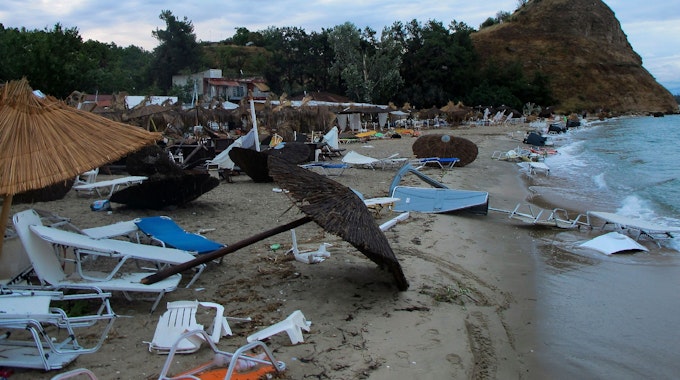 rümmer, umgekippte Sonnenschirme und Strandliegen liegen an einem Strand bei Nea Plagia in der Region Chalkidiki in Nordgriechenland. Dort kam es im Juli 2022 zu einem heftigen Unwetter.