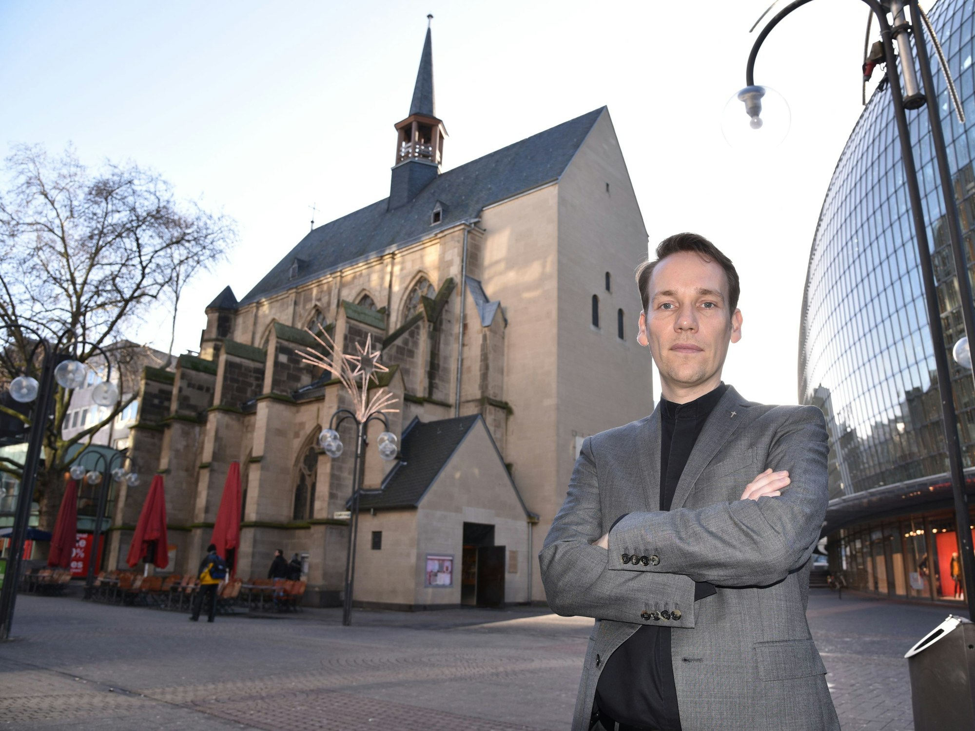 Markus Herzberg, Pfarrer der evangelischen Antoniterkirche auf der Schildergasse, steht vor einer Kirche.