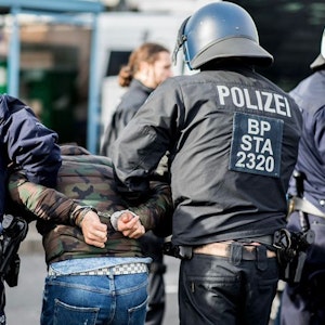 Ein Demonstrant wird von Polizisten am Düsseldorfer Flughafen festgenommen.