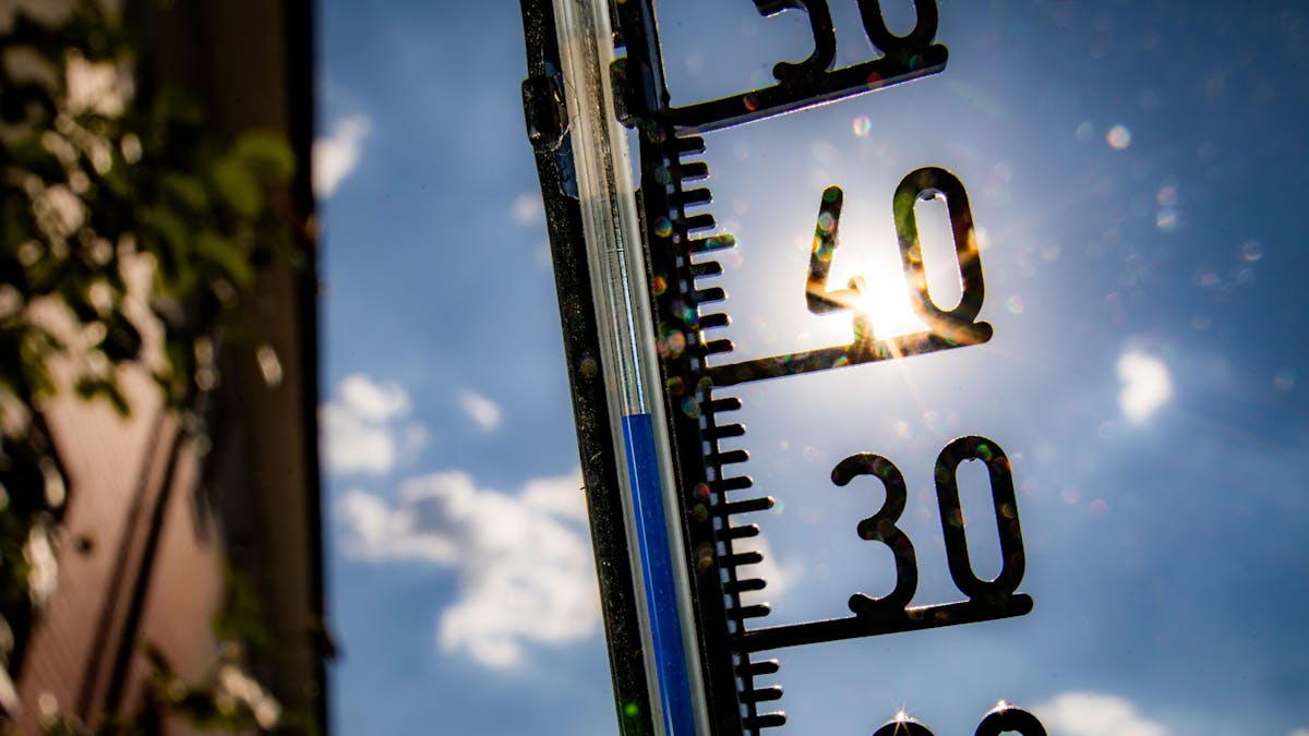 Ein Thermometer an einer Hauswand klettert in Richtung der 40-Grad-Marke.