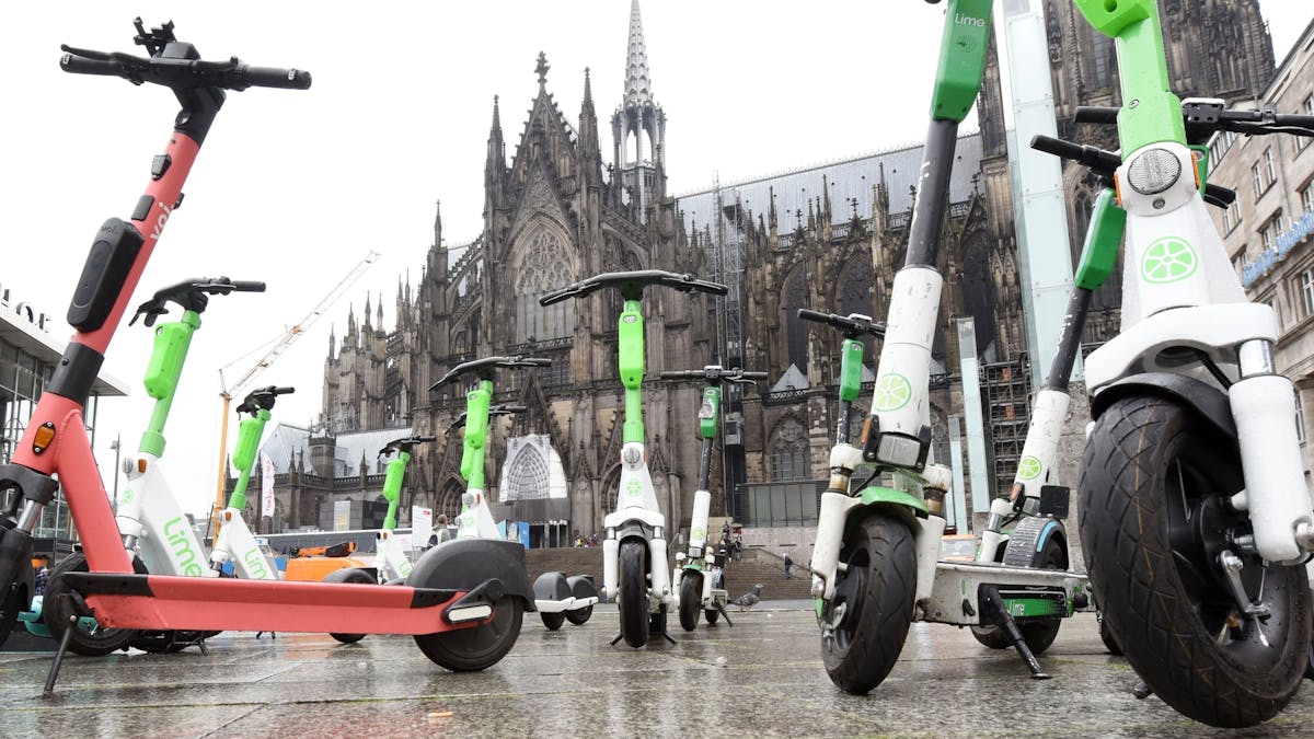 Elektroroller stehen auf dem Bahnhofsvorplatz in Köln.