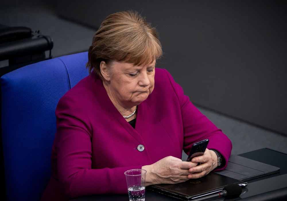 Dieses Foto aus dem Jahr 2020 zeigt die damalige Bundeskanzlerin Angela Merkel, wie sie ihr Handy im Bundestag benutzt.