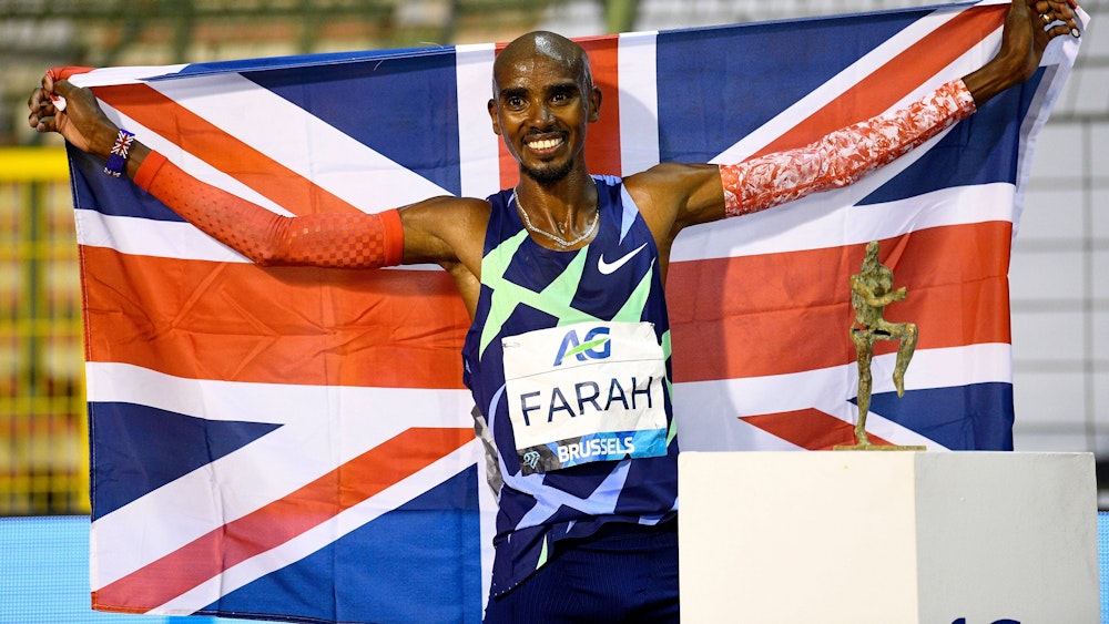 Mo Farah hält die Flagge Großbritanniens und posiert mit dem Pokal.