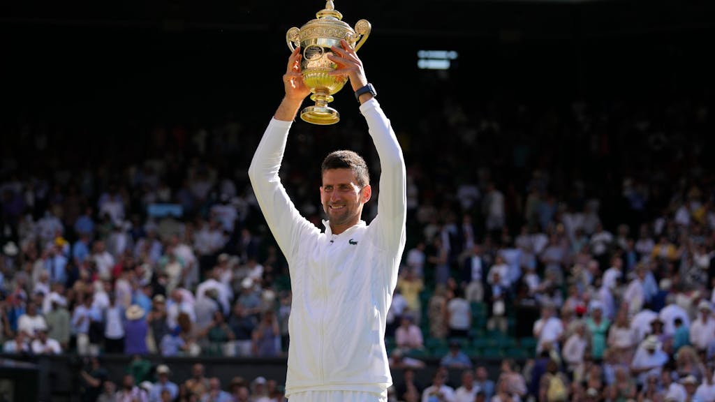 Novak Djokovic hält die Wimbledon-Trophäe über seinem Kopf.&nbsp;