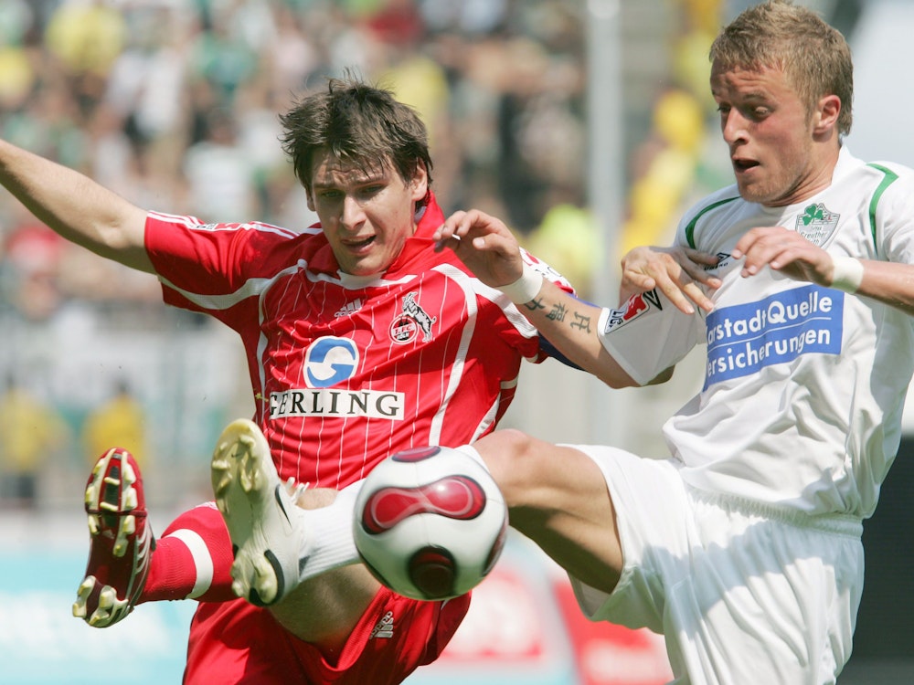 Daniel Adlung von Fürth und Patrick Helmes vom FC Köln heben das Bein, um an den Ball zu kommen.